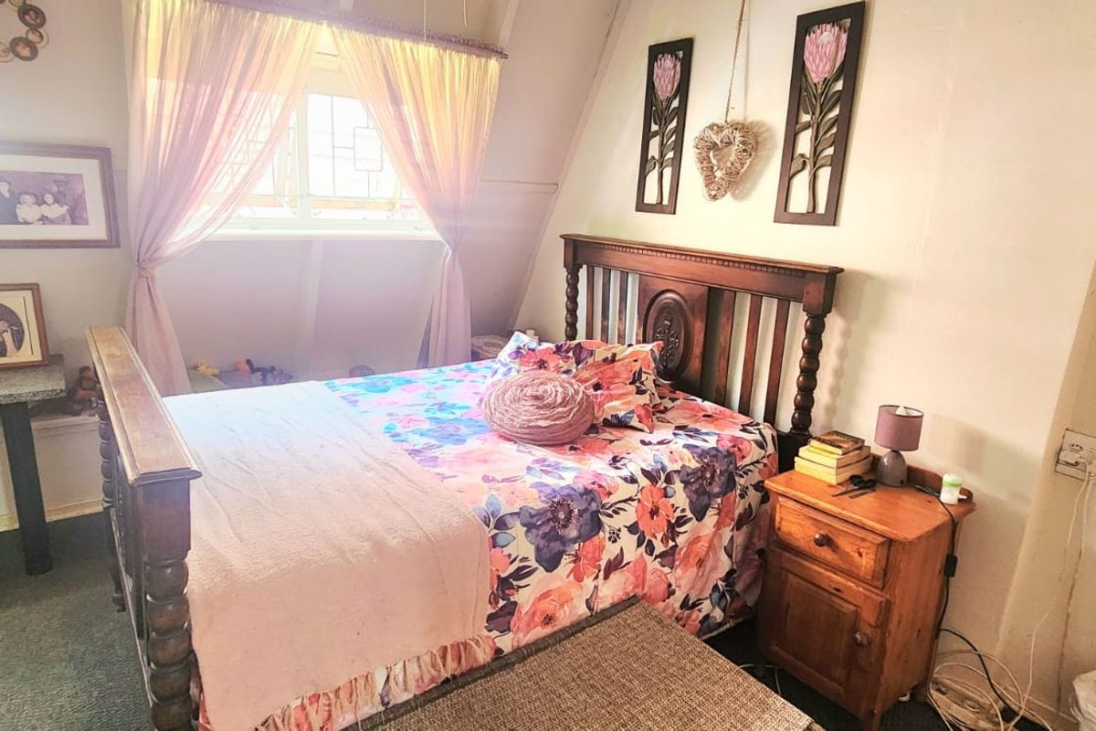 A cozy bedroom featuring a built-in desk area and a window with natural light, offering a functional space for rest and study.