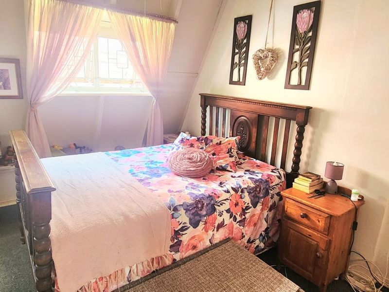 A cozy bedroom featuring a built-in desk area and a window with natural light, offering a functional space for rest and study.