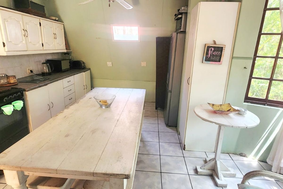 A dated kitchen featuring built-in cabinetry, tiled flooring, and an electric stove, offering potential for modernization and renovation.
