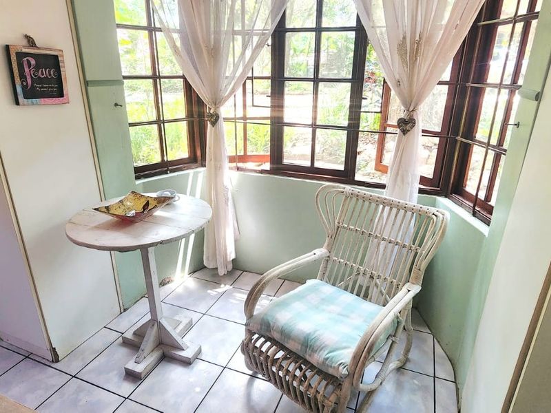 A cozy nook area featuring tiled flooring, a bay window with natural light, and built-in storage cabinetry.