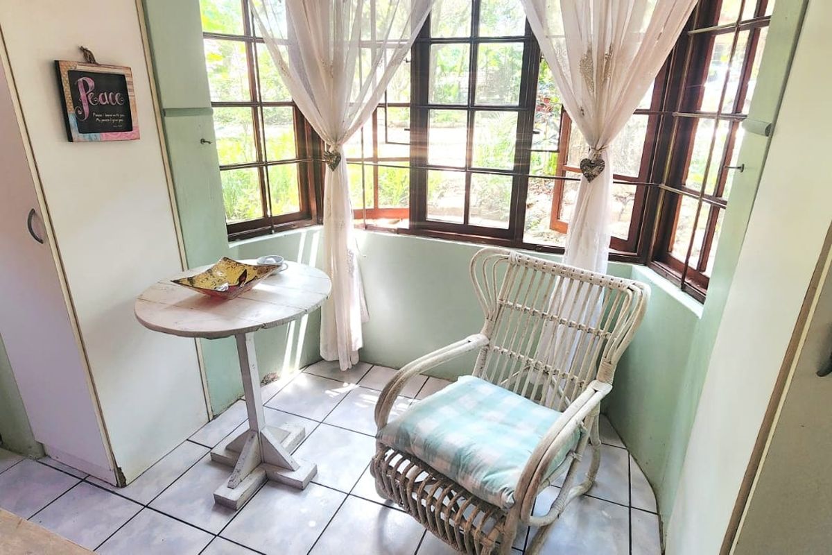 A cozy nook area featuring tiled flooring, a bay window with natural light, and built-in storage cabinetry.
