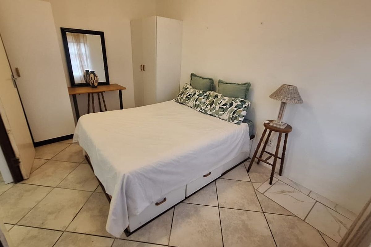 A functional bedroom featuring tiled flooring and neutral wall finishes, providing a simple and practical living space.