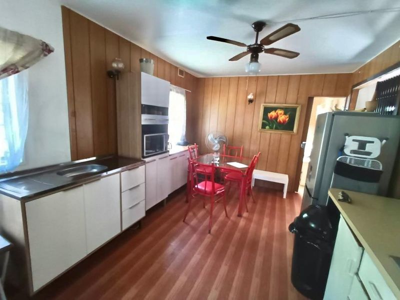 A dated kitchen featuring wood paneling, built-in cabinetry, and an integrated oven, offering potential for a modern renovation.