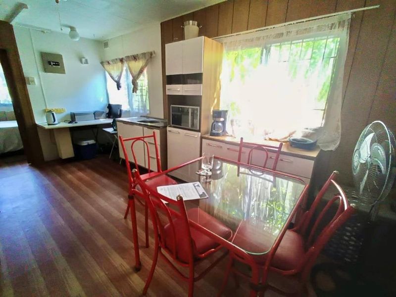 A dated kitchen area featuring built-in cabinetry, laminate countertops, and timber flooring, offering potential for a modern renovation.
