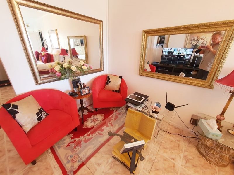A cozy seating area featuring large decorative wall mirrors and tiled flooring, providing a bright and reflective space within the home.