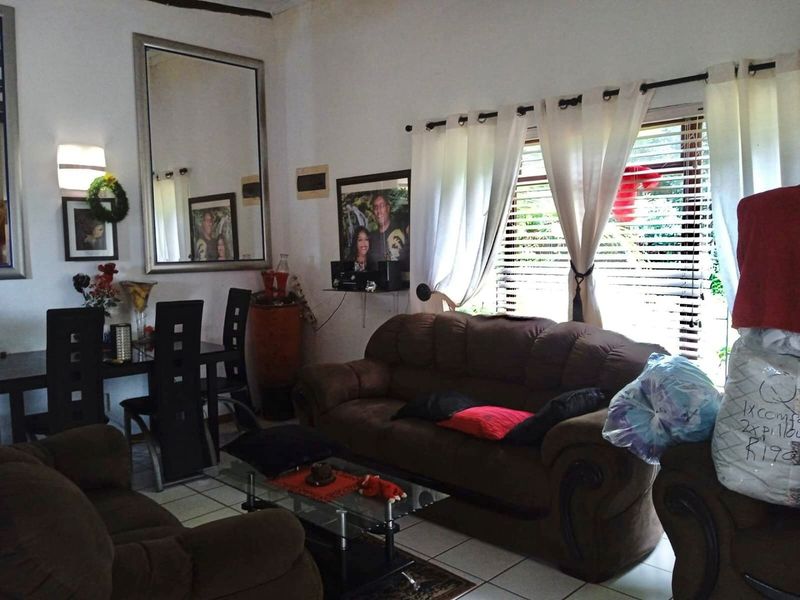 A living room area featuring tiled flooring and window treatments, providing a functional space for relaxation and dining.