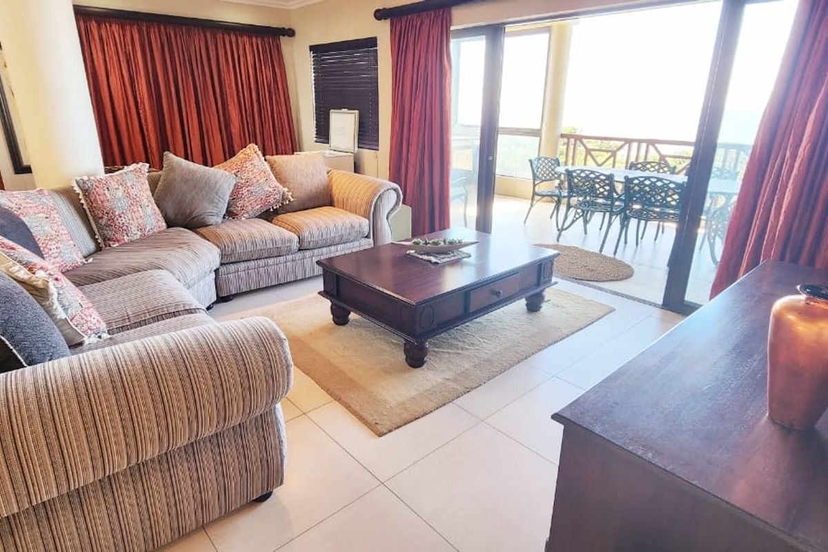 Spacious living room featuring large sliding glass doors that open onto a private balcony, providing ample natural light and seamless indoor-outdoor flow.