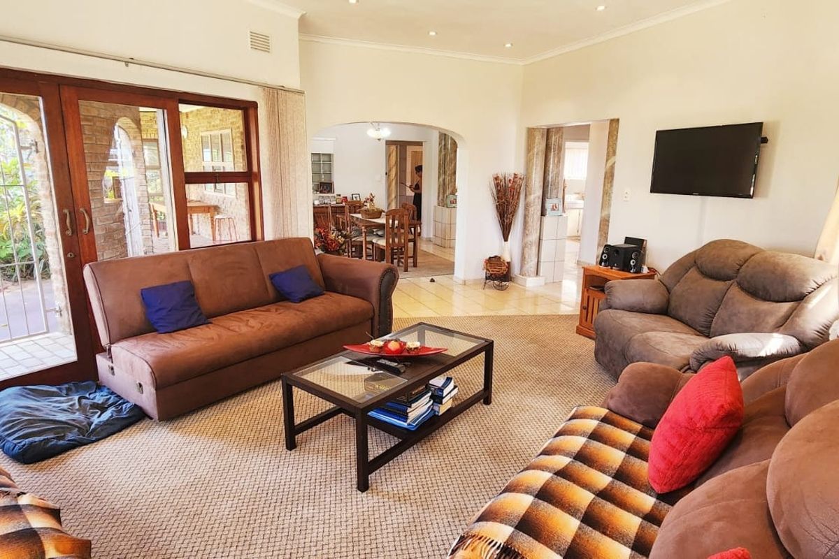 Spacious living room featuring large sliding glass doors providing natural light, neutral wall finishes, and an open-plan flow into the adjacent dining area.