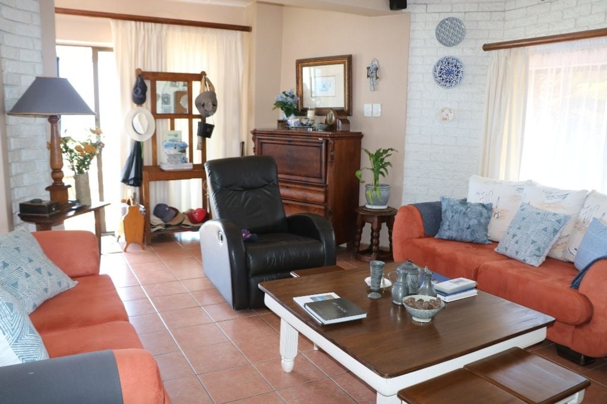 A comfortable living room featuring tiled flooring, a brick fireplace surround, and direct access to an outdoor area through a sliding glass door.