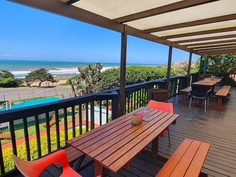 Spacious covered timber deck balcony offering expansive ocean views and direct outdoor access.