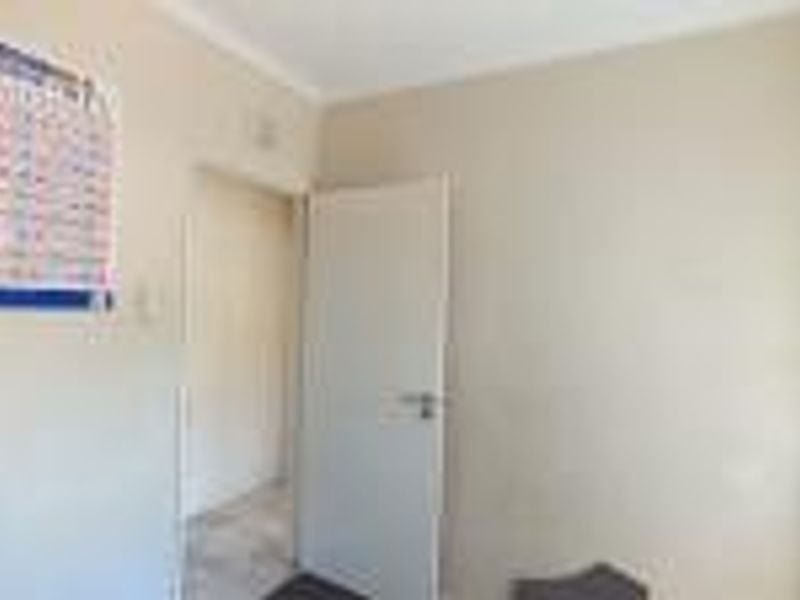 A vacant bedroom featuring neutral walls and standard interior door, requiring cosmetic updates to improve its overall appeal.