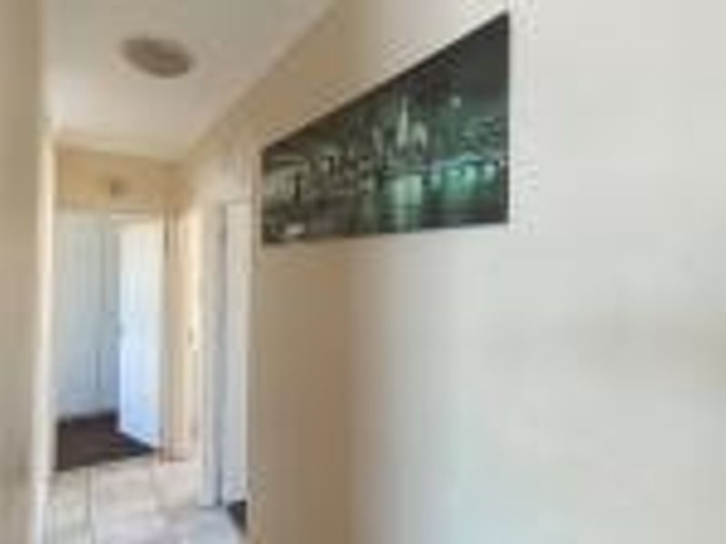 A functional apartment hallway featuring tiled flooring and neutral wall finishes, providing access to adjacent rooms.