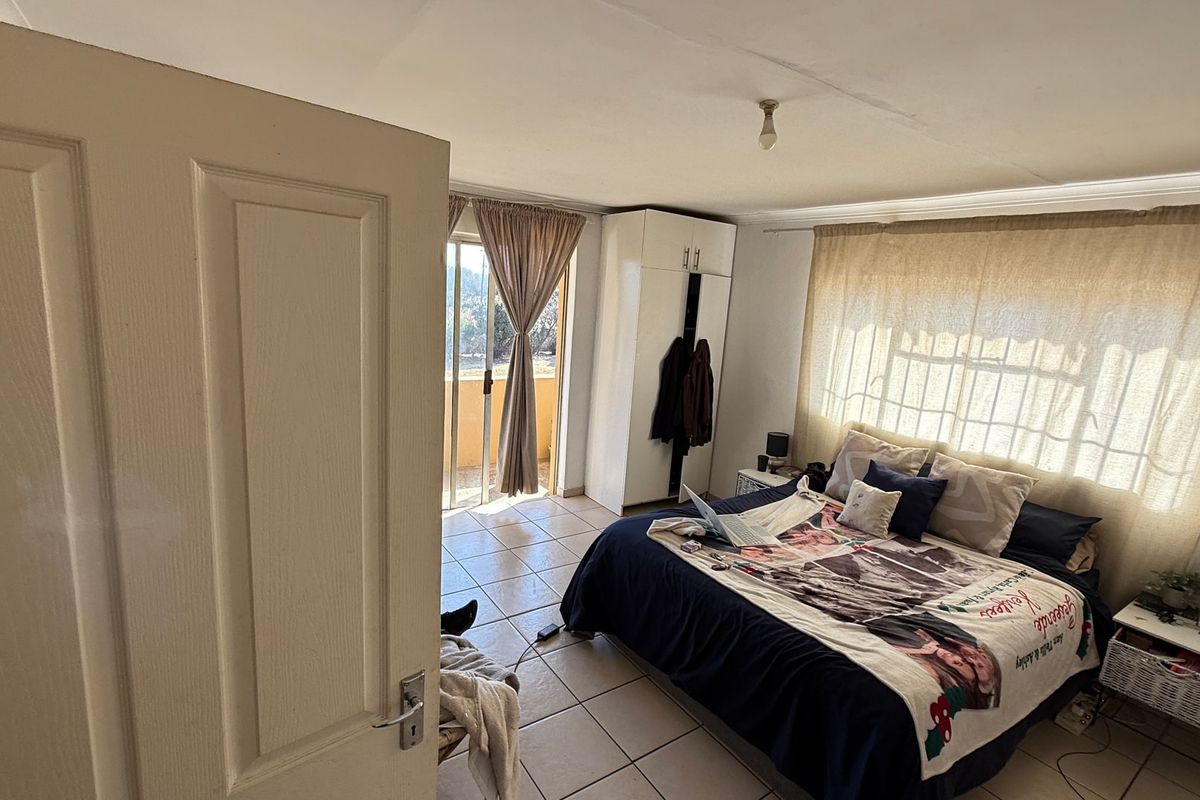 A bedroom featuring tiled flooring, built-in wardrobe, and direct access to an outdoor balcony area.
