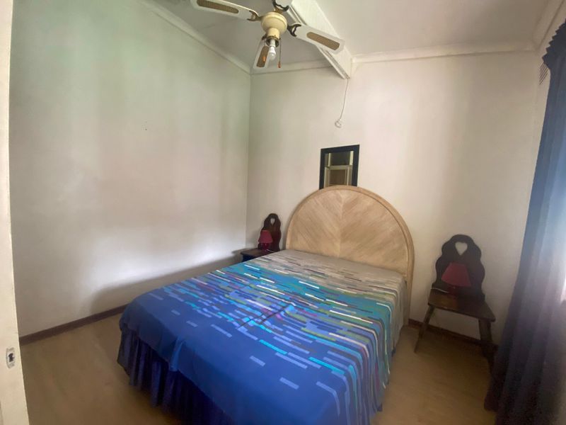 A standard bedroom featuring a ceiling fan and neutral wall finishes, offering a functional space ready for modern updates.