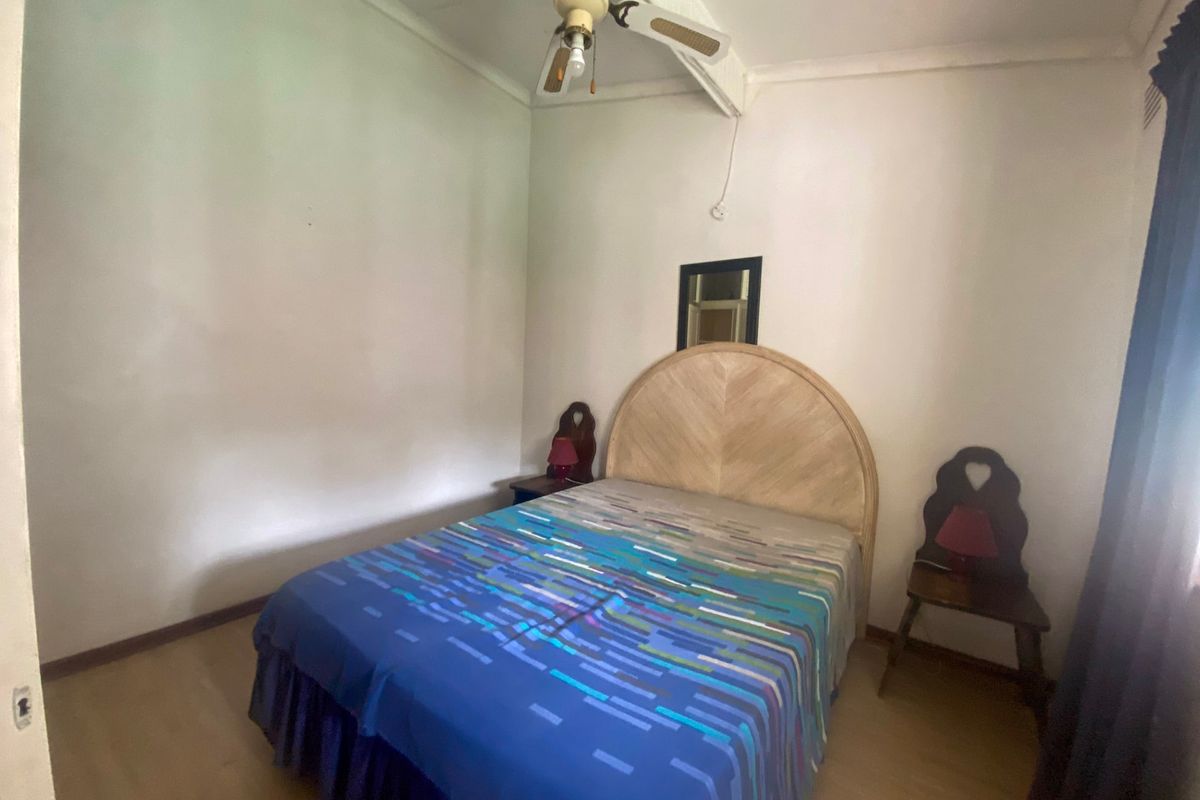 A standard bedroom featuring a ceiling fan and neutral wall finishes, offering a functional space ready for modern updates.