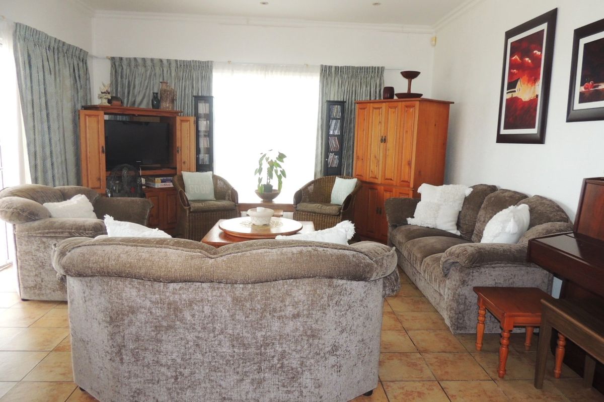 A spacious living room featuring tiled flooring and recessed ceiling lighting, offering a comfortable and functional area for relaxation.