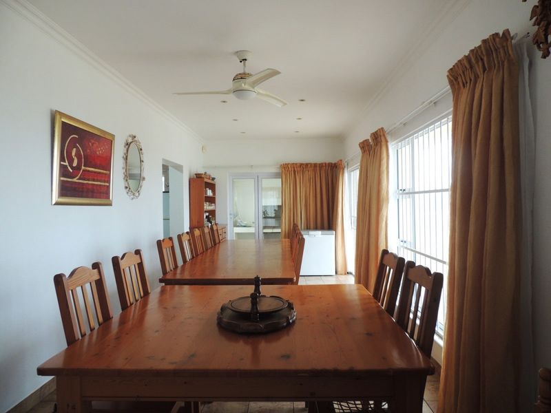 Spacious dining area featuring tiled flooring, recessed lighting, a ceiling fan, and large windows fitted with security bars.