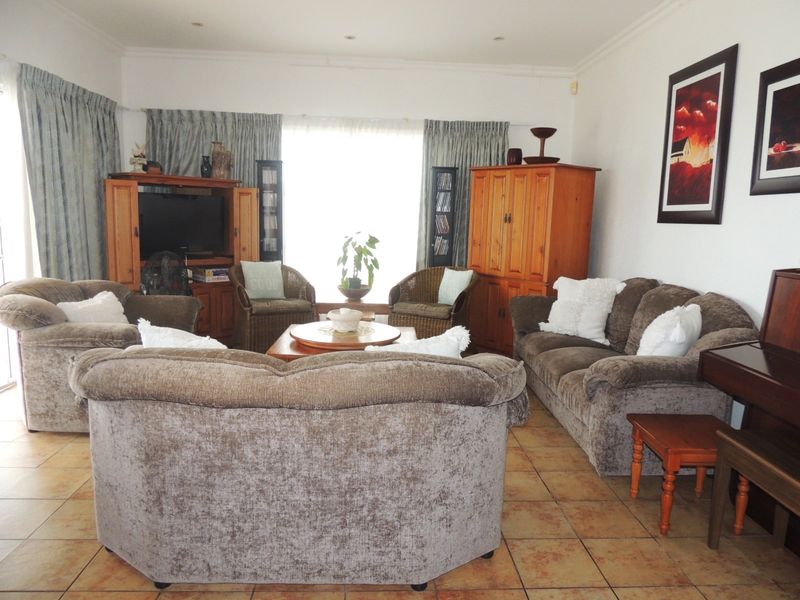 A spacious living room featuring tiled flooring and recessed ceiling lighting, offering a comfortable and functional area for relaxation.