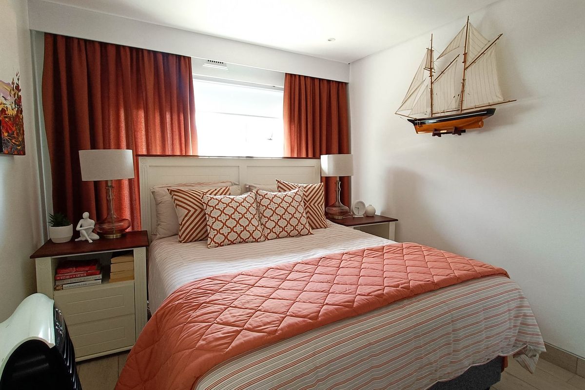 A well-maintained bedroom featuring tiled flooring, recessed lighting, and integrated curtain tracks, providing a comfortable and functional living space.