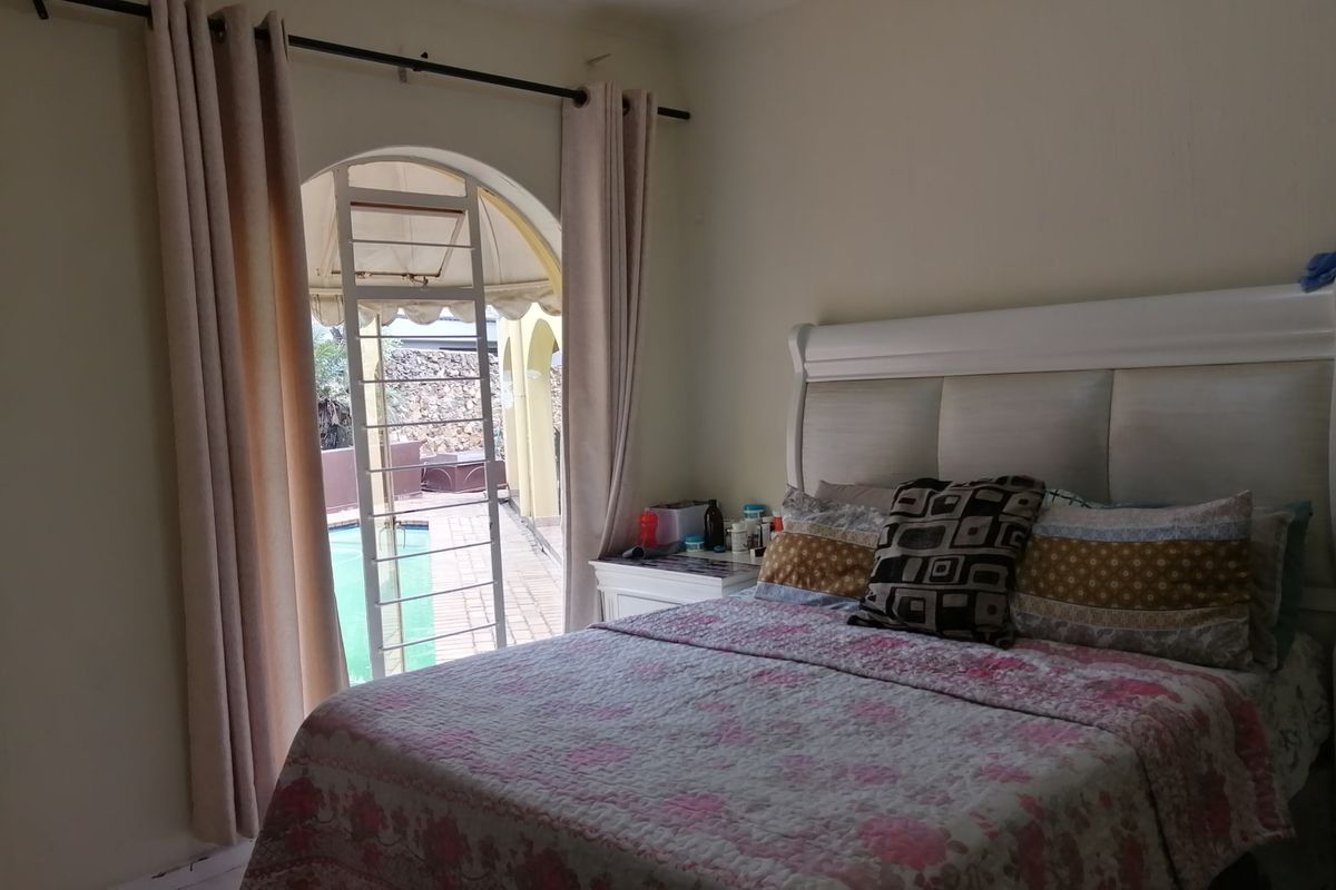 Bedroom featuring an arched doorway with security gate, providing direct access to the outdoor pool area.