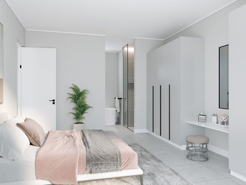 Modern bedroom featuring built-in wardrobes, a sleek integrated vanity, and direct access to an en-suite bathroom with contemporary finishes.