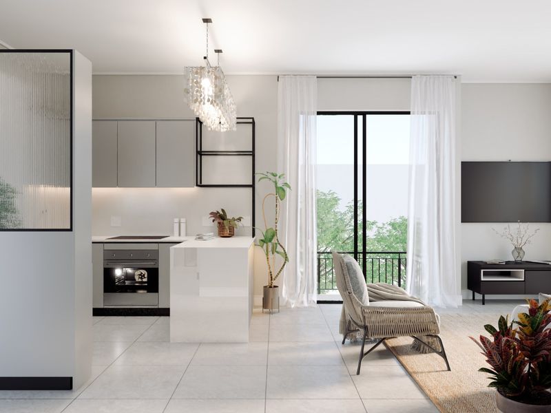 Modern open-plan living area featuring a sleek kitchen with built-in appliances, a central island, and a stylish fluted glass room divider.