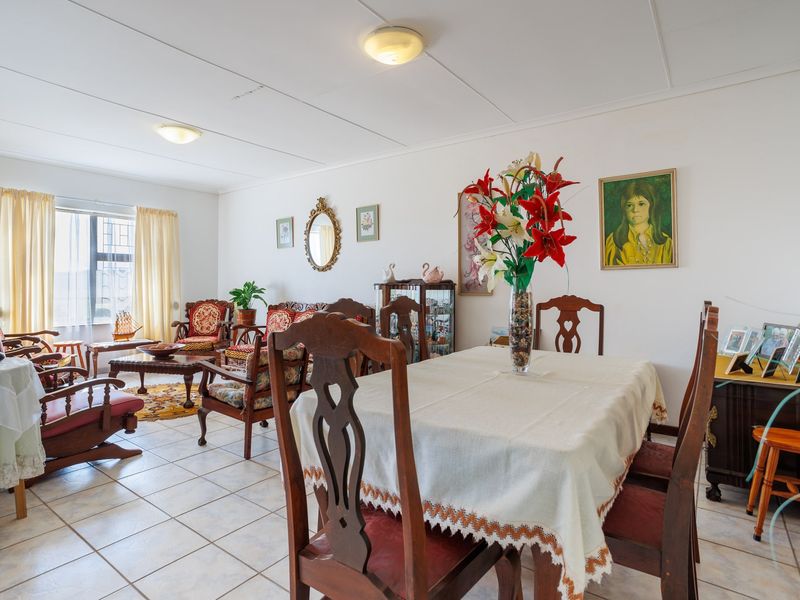 Spacious open-plan living and dining area featuring neutral ceramic floor tiles and ample natural light from the window.