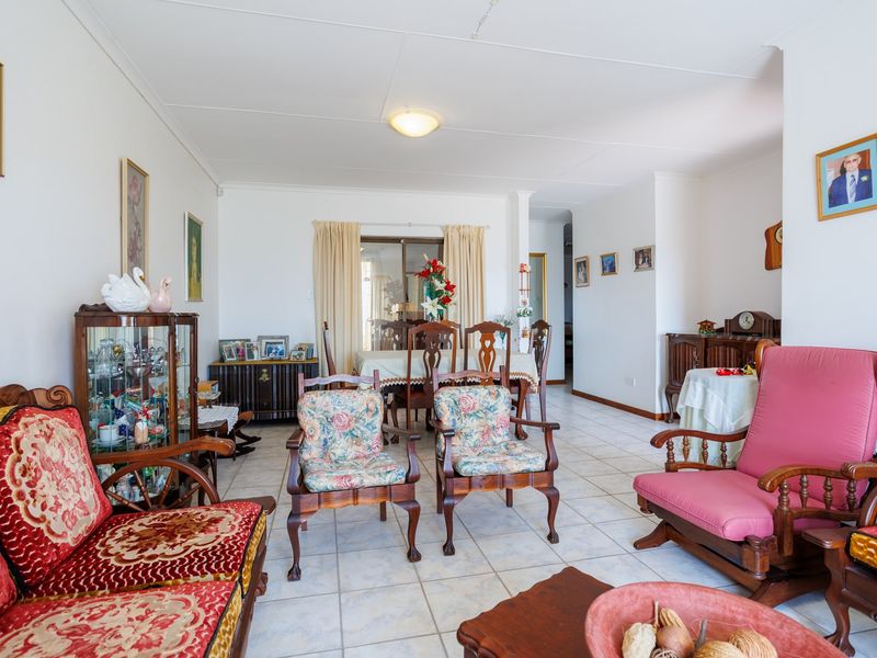 An open-plan living and dining area featuring ceramic floor tiles and a sliding glass door leading to the exterior.