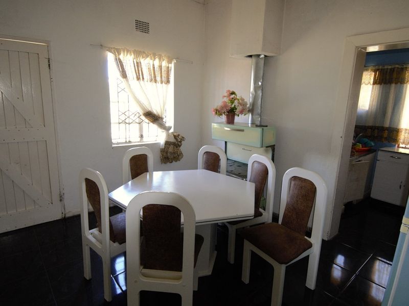Dining area featuring dark tiled flooring, a built-in ventilation point, and a vintage-style freestanding fireplace.