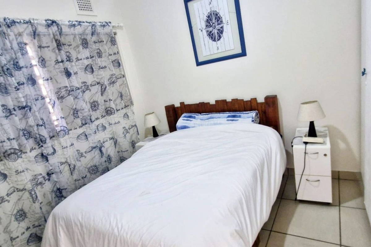 A functional bedroom featuring tiled flooring and a built-in cupboard, offering a clean and simple living space.