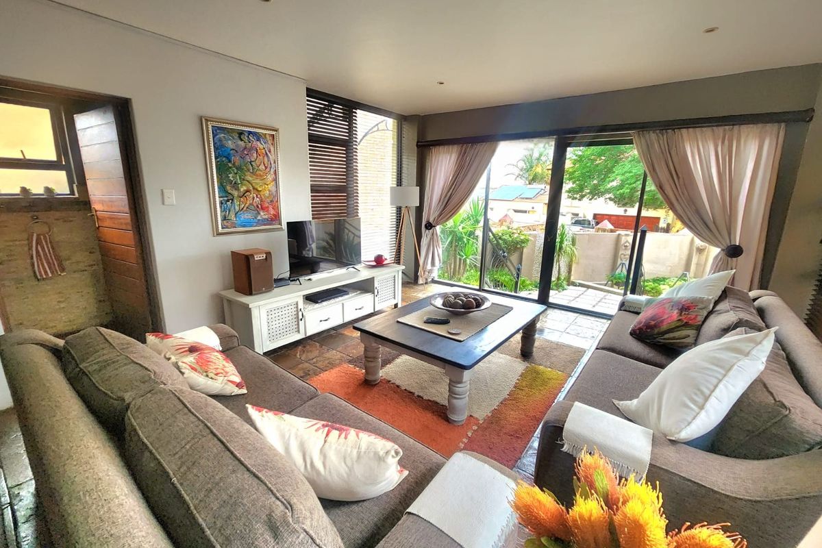 A comfortable living room featuring large sliding glass doors that provide natural light and direct access to the outdoor patio area.