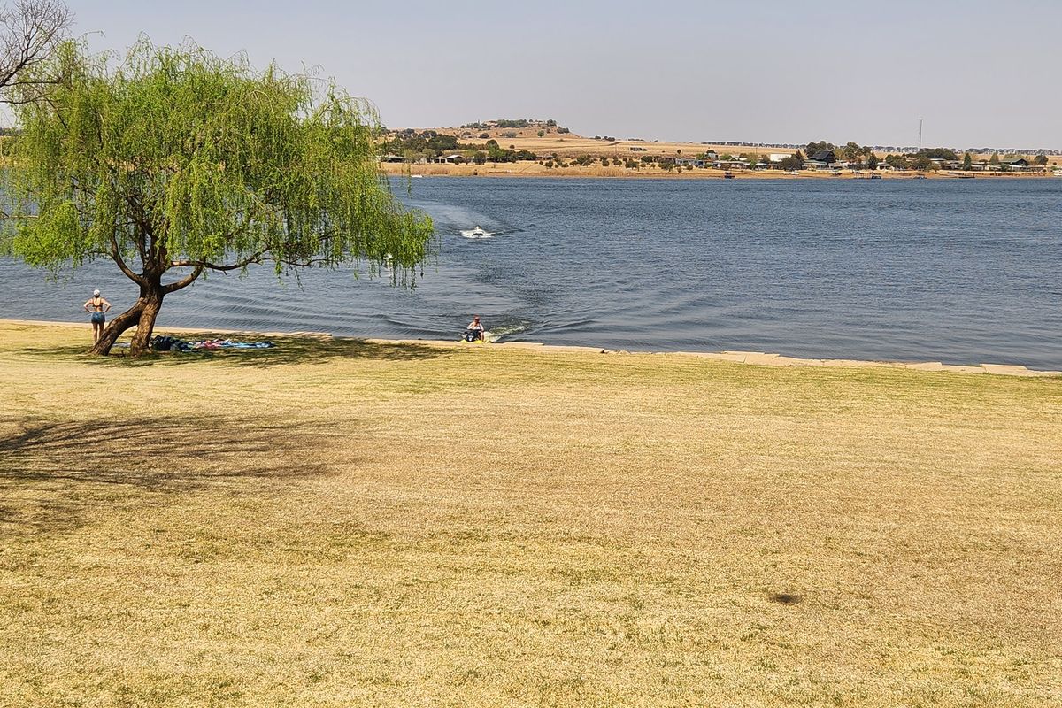 A scenic view of the waterfront featuring a grassy lawn and direct access to the lake, ideal for recreational activities.