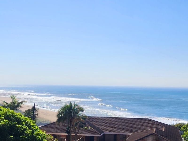 A scenic elevated view overlooking the coastline, ocean, and surrounding landscape, showcasing the property's prime coastal location.