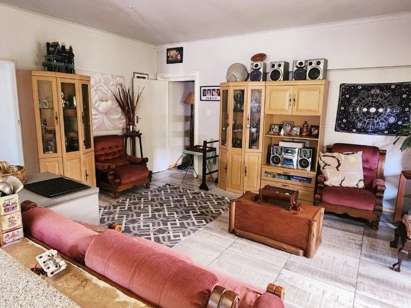 A spacious living area featuring tiled flooring and neutral wall finishes, offering a functional layout for comfortable family living.