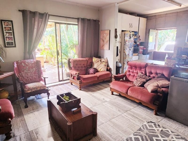 Open plan living area featuring tiled flooring and a sliding glass door providing access to the outdoor patio area.