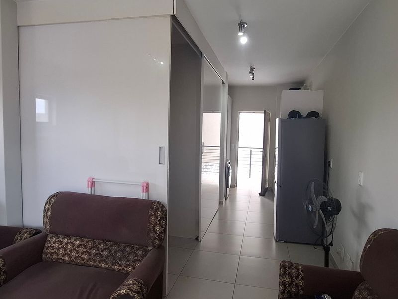 Open plan living area featuring tiled flooring and modern sliding doors leading to an adjacent space.