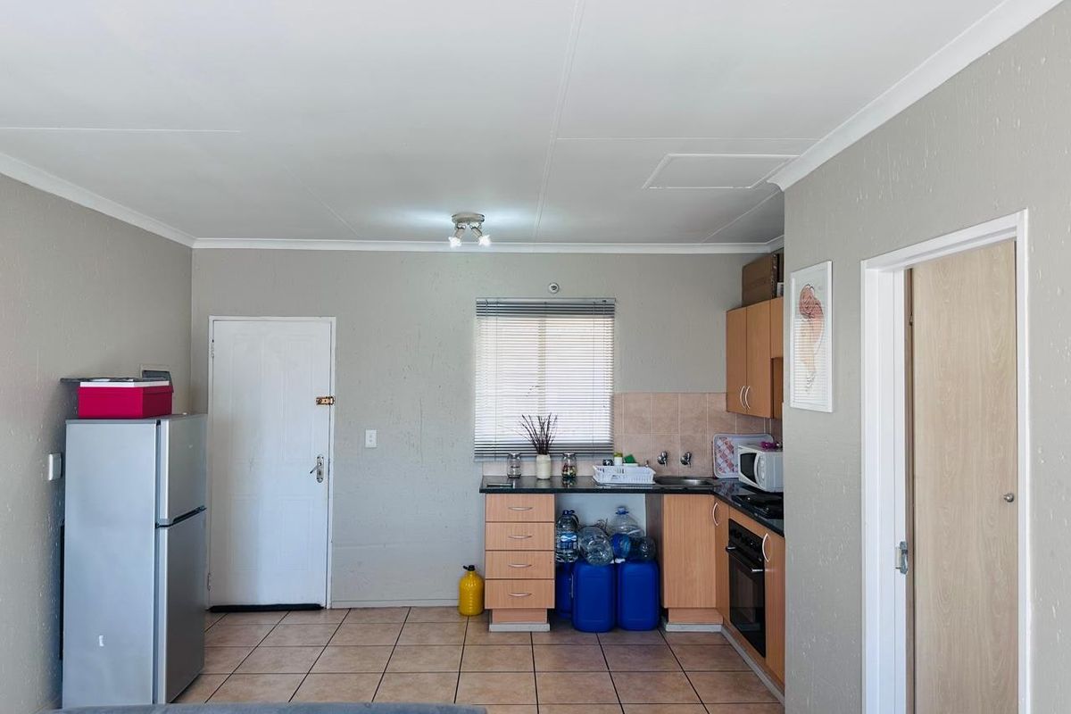 A functional kitchen area featuring built-in cabinetry, a built-in oven, hob, and tiled flooring, offering a practical layout for daily use.