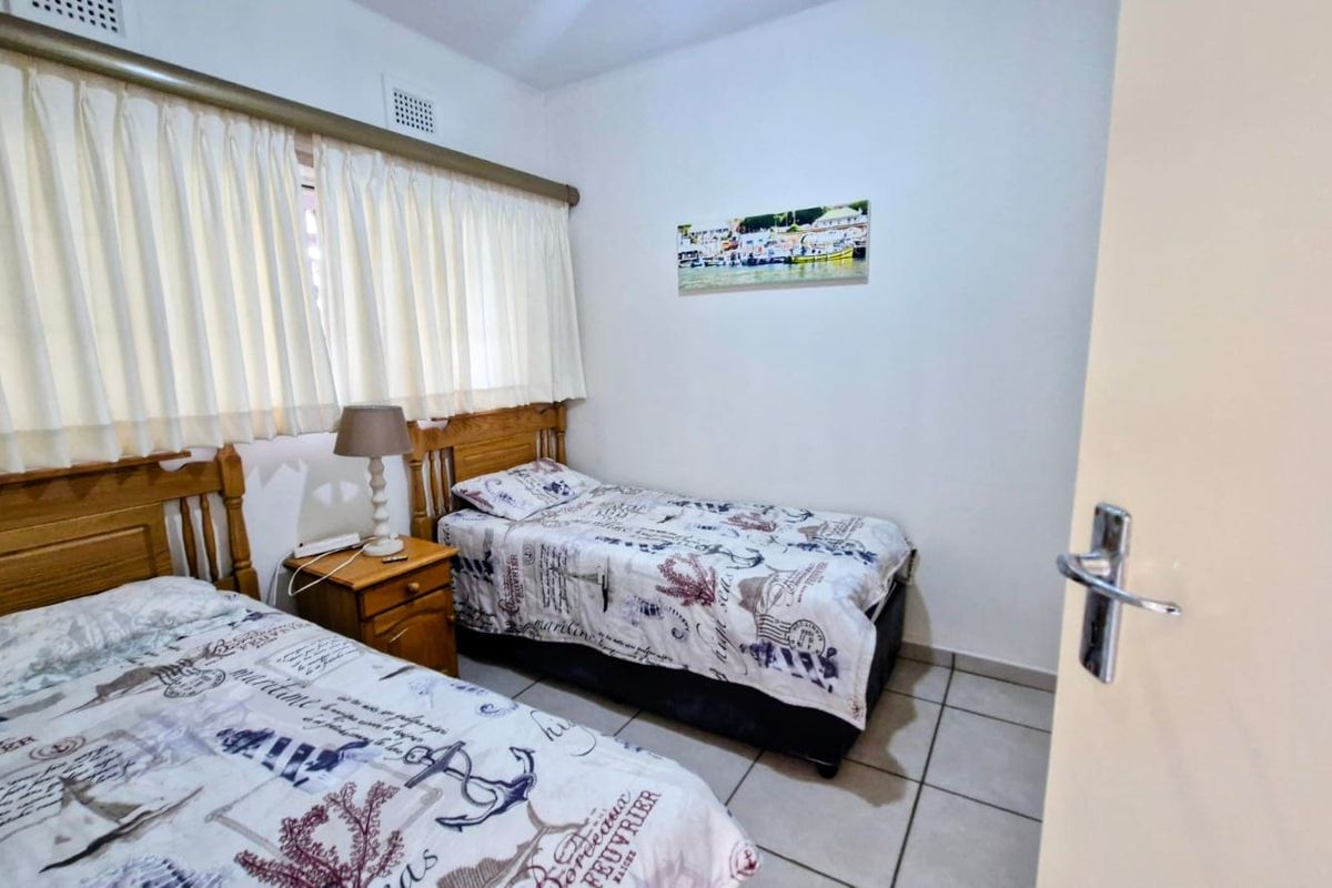 A functional bedroom featuring tiled flooring and a ceiling air vent, providing a simple and practical living space.