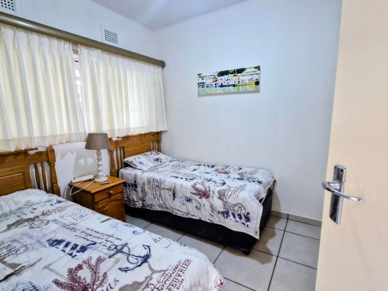 A functional bedroom featuring tiled flooring and a ceiling air vent, providing a simple and practical living space.