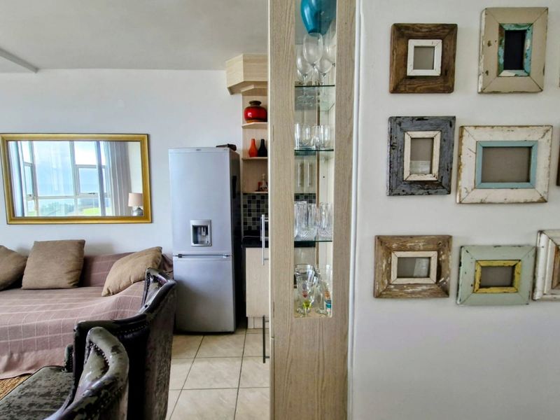 Open plan living area featuring tiled flooring, a built-in display cabinet, and an integrated air conditioning unit.