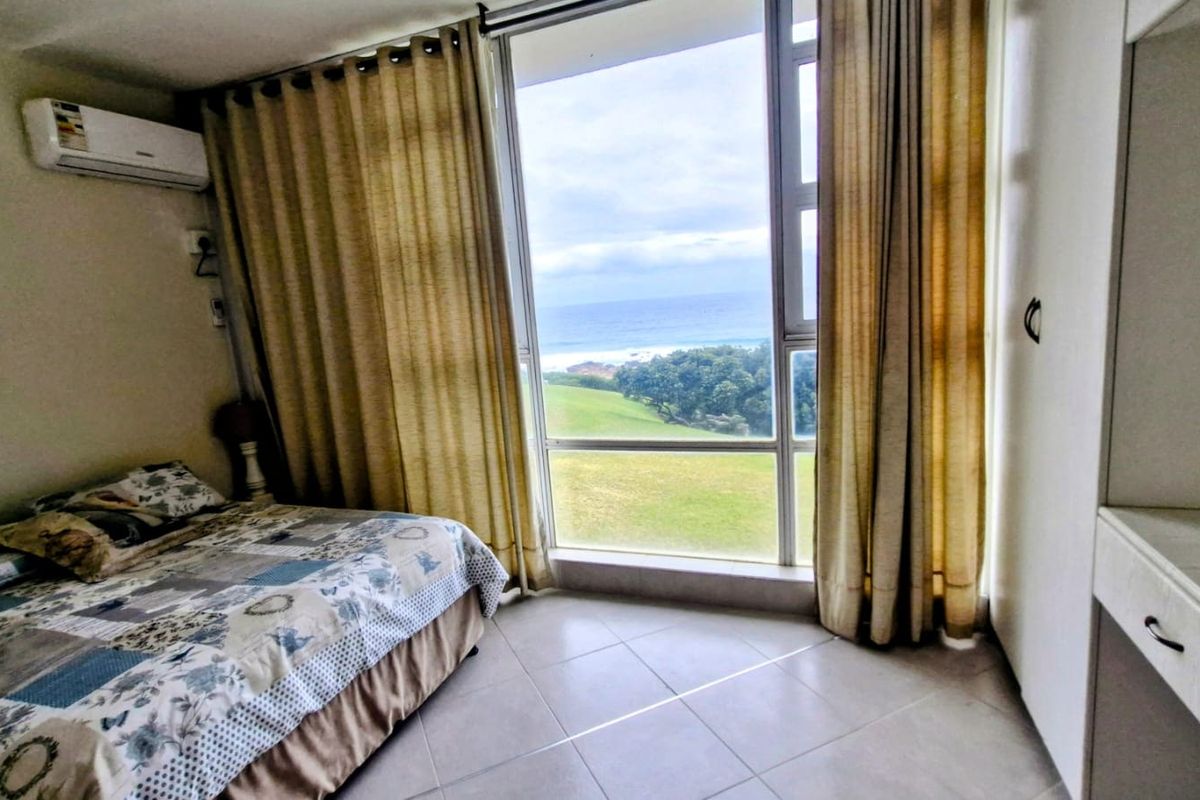 A bedroom featuring tiled floors, built-in cabinetry, an air conditioning unit, and a large window offering scenic coastal and landscape views.