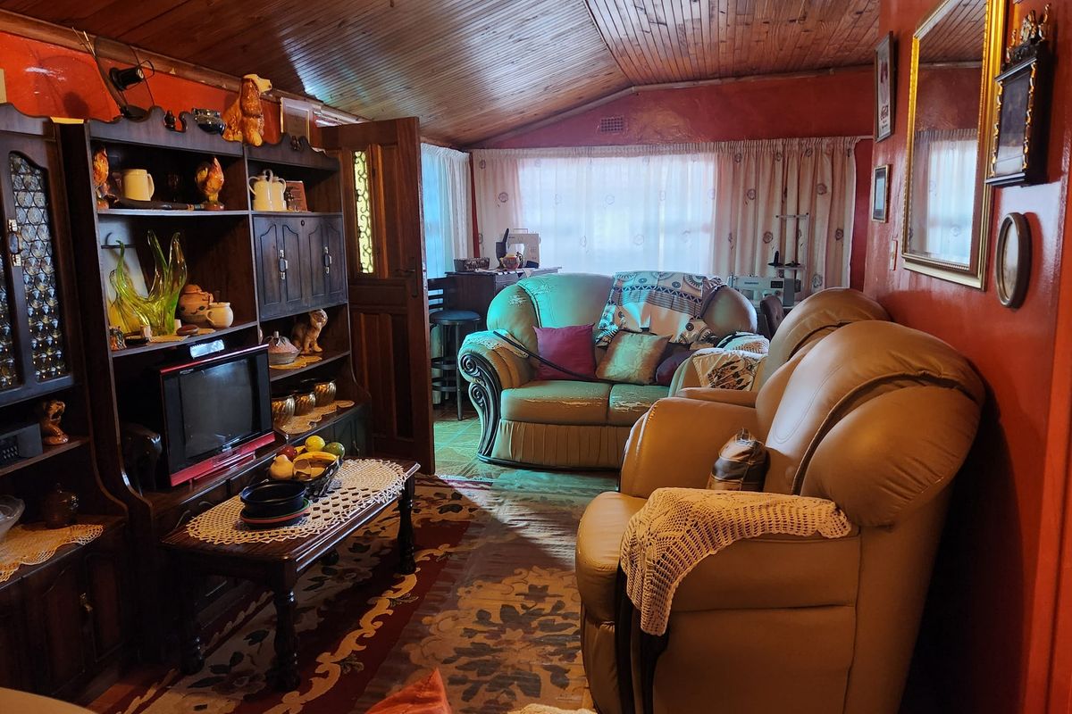 A living room featuring a vaulted timber-clad ceiling and traditional finishes, offering a cozy atmosphere with potential for modernization.
