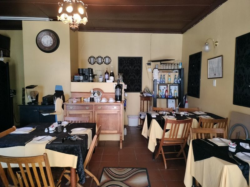 A dining area featuring tiled flooring and built-in cabinetry, currently set up with multiple tables for service.