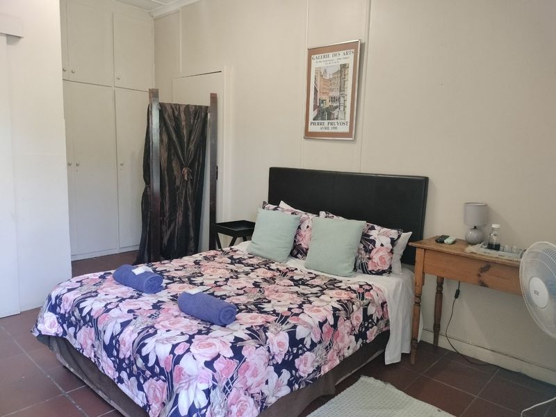 A functional bedroom featuring built-in cupboards and tiled flooring, offering a neutral base for potential interior updates.