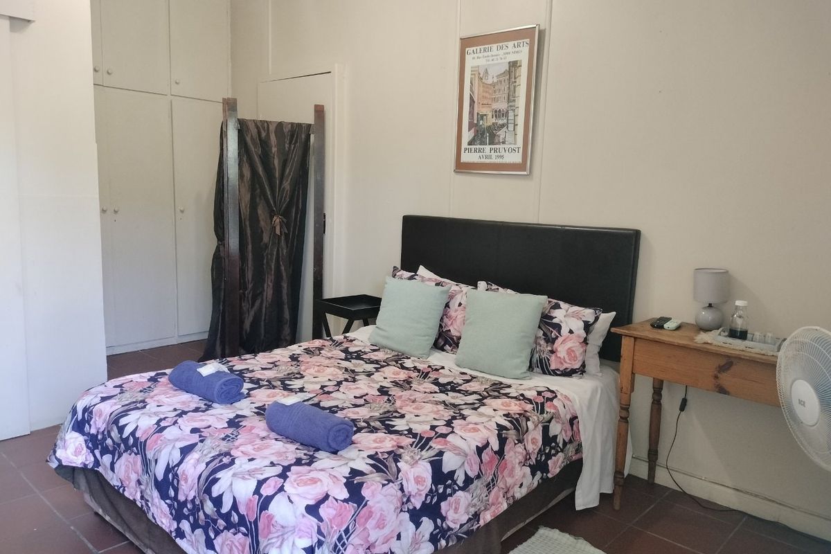 A functional bedroom featuring built-in cupboards and tiled flooring, offering a neutral base for potential interior updates.