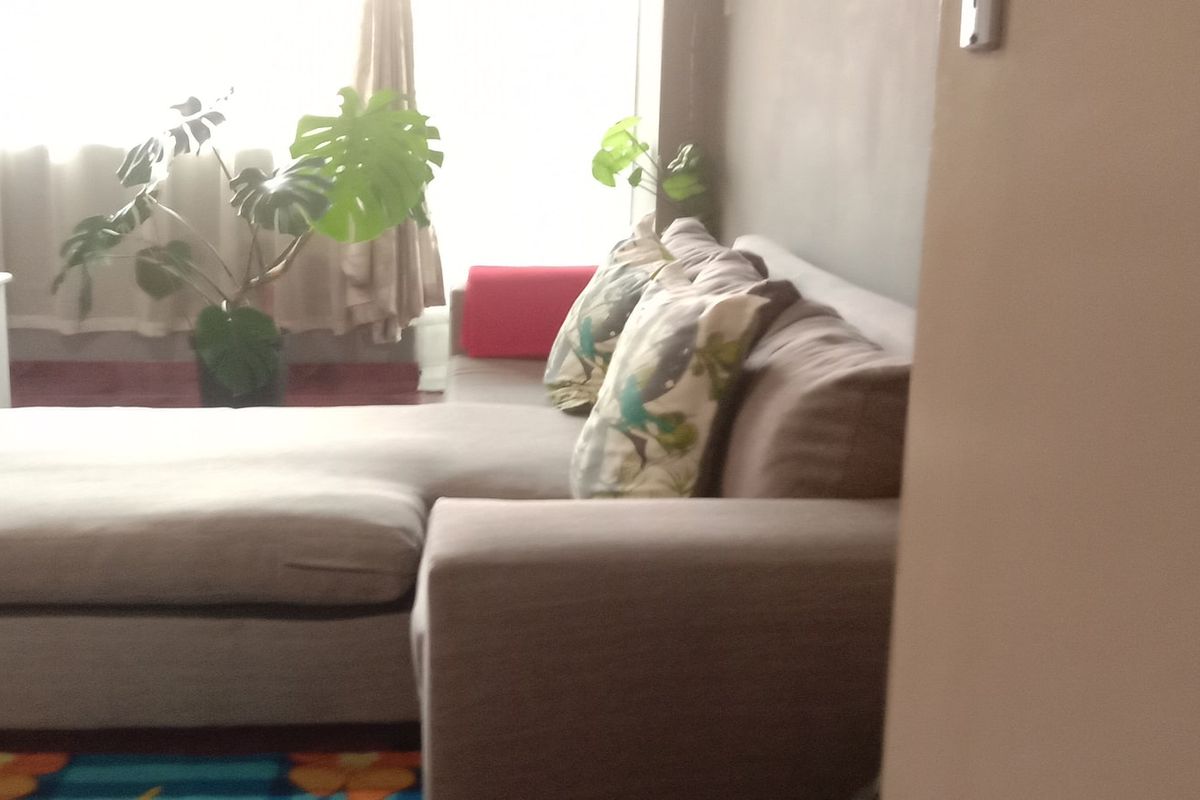 A view of a living room area featuring natural light from a large window.
