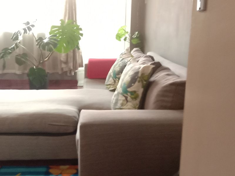A view of a living room area featuring natural light from a large window.
