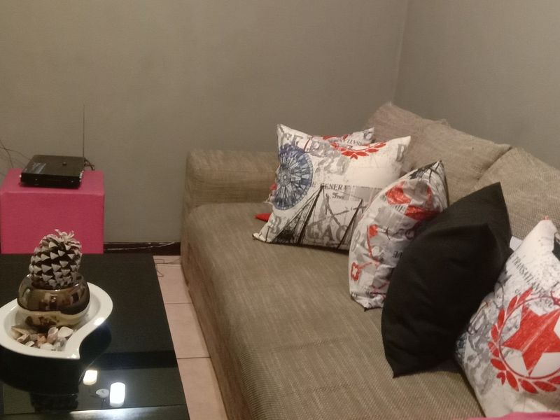 A living room area featuring neutral wall tones and tiled flooring, providing a functional space for relaxation.