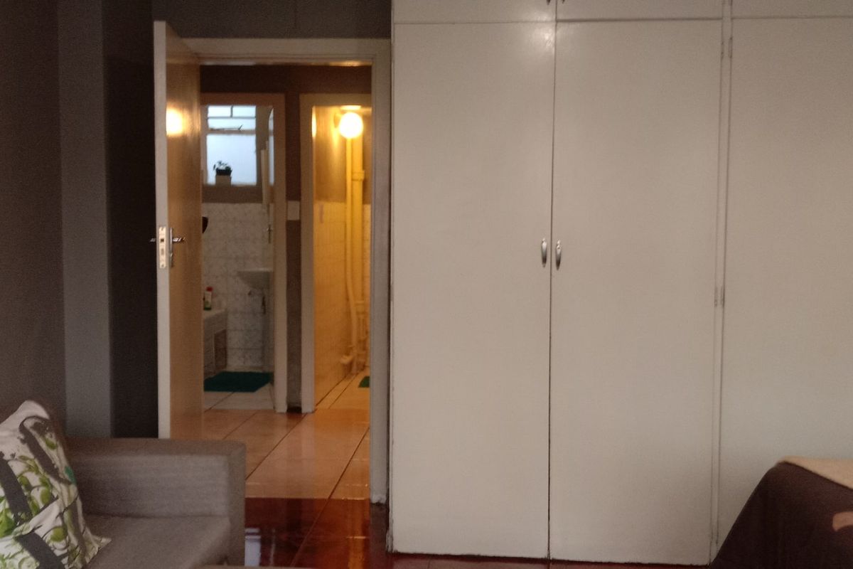 Bedroom featuring built-in cupboards and direct access to an adjacent bathroom area.