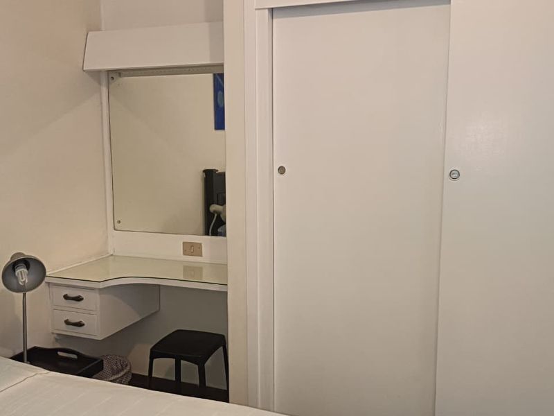 Bedroom featuring a built-in vanity with mirror and a white sliding door wardrobe.